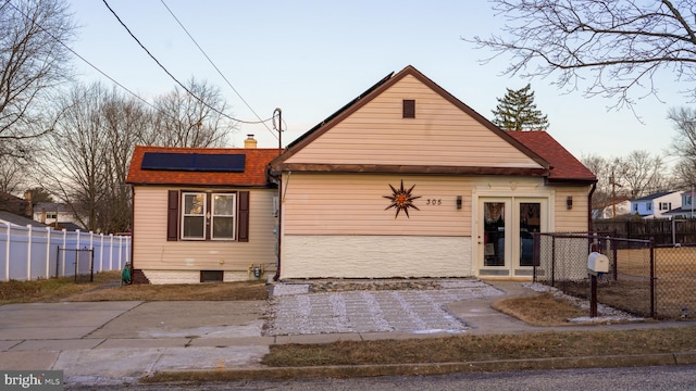 bungalow-style house with french doors and solar panels