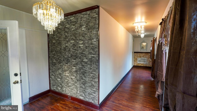 corridor with a chandelier, a wall mounted air conditioner, and dark hardwood / wood-style flooring