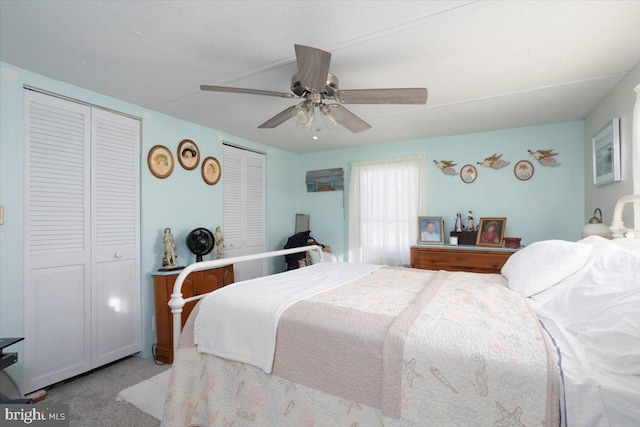 bedroom featuring ceiling fan, two closets, and light carpet