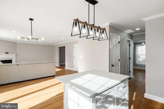 kitchen featuring a kitchen island, an inviting chandelier, ornamental molding, and hardwood / wood-style flooring