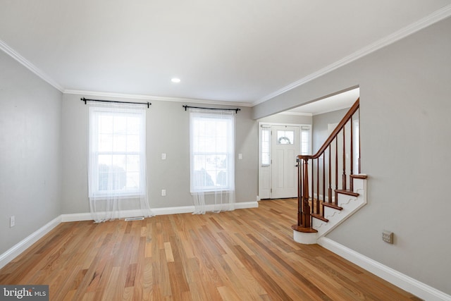 foyer entrance with ornamental molding and light wood-type flooring