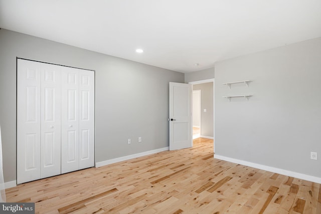 unfurnished bedroom with a closet and light hardwood / wood-style floors