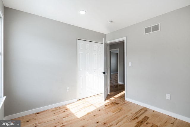 unfurnished bedroom with a closet and light hardwood / wood-style flooring