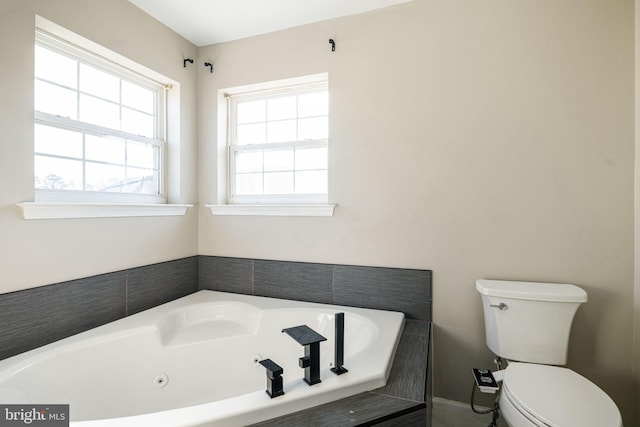 bathroom featuring a tub to relax in and toilet