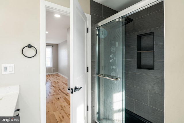 bathroom featuring an enclosed shower, vanity, and hardwood / wood-style floors