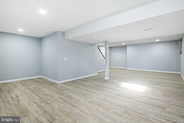 basement with light hardwood / wood-style flooring