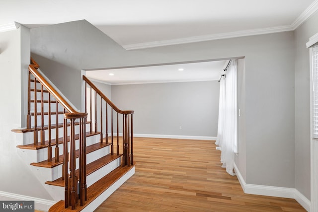 stairway with hardwood / wood-style flooring, ornamental molding, and a wealth of natural light