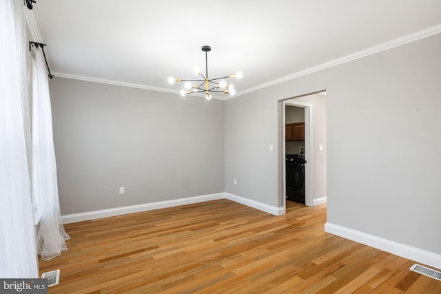 spare room with light wood-type flooring, washer / clothes dryer, crown molding, and a chandelier