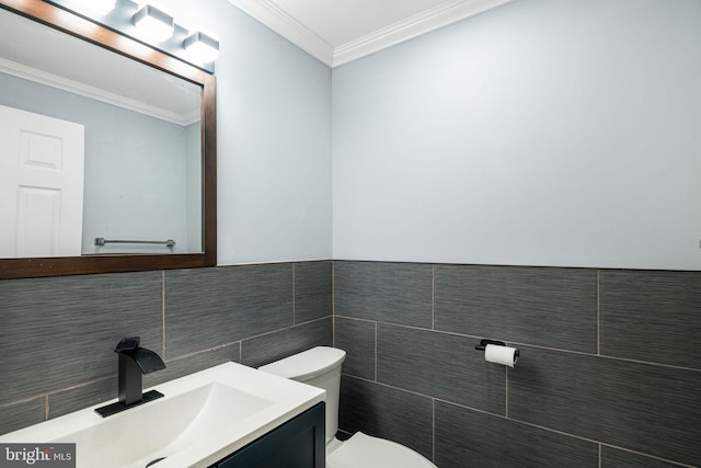 bathroom with toilet, crown molding, tile walls, and vanity