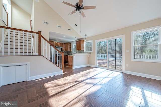 unfurnished living room featuring high vaulted ceiling, dark parquet flooring, and ceiling fan