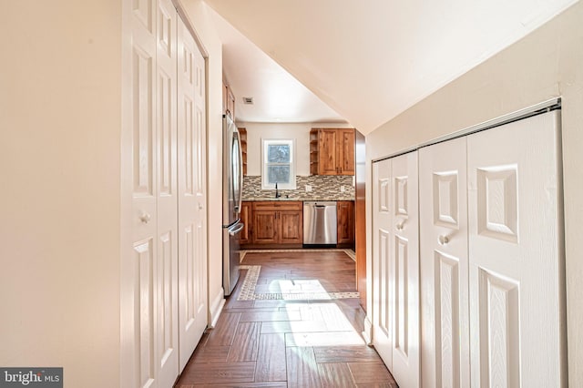 corridor with sink, vaulted ceiling, and dark parquet floors