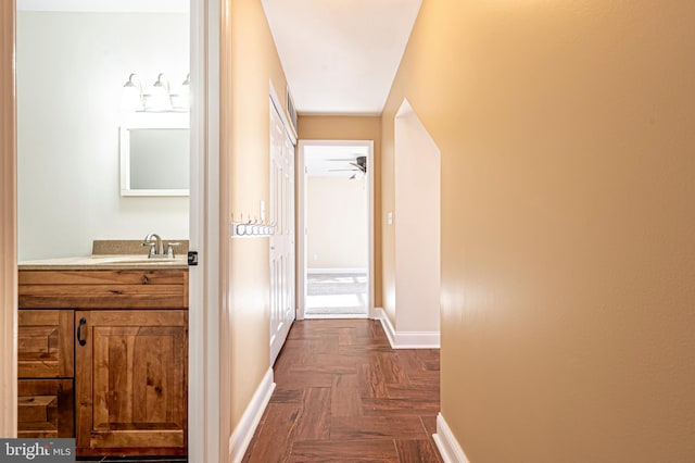 hall with dark parquet floors and sink