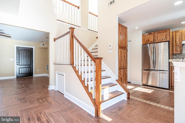 stairs featuring parquet flooring and a towering ceiling