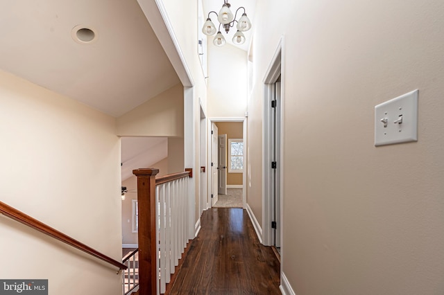 hall with lofted ceiling, a notable chandelier, and dark hardwood / wood-style floors