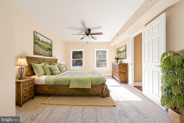 bedroom with ceiling fan, multiple windows, and light carpet