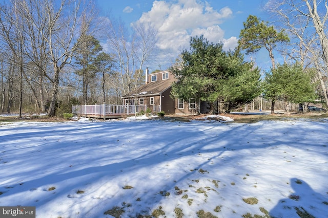 yard layered in snow featuring a wooden deck