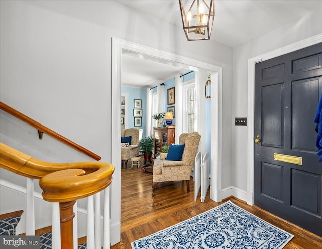 foyer with dark hardwood / wood-style flooring and a notable chandelier