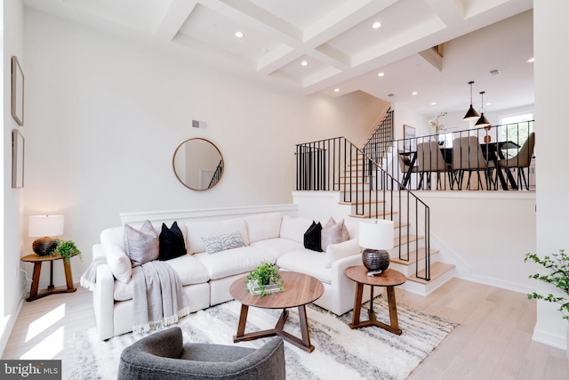 living room with beamed ceiling, light wood-type flooring, and coffered ceiling