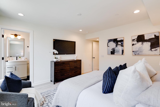 bedroom with ensuite bath and light hardwood / wood-style flooring