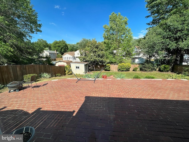 8107 Orville St, Alexandria, VA 22309 - view of patio featuring a fenced backyard, an outdoor structure, a storage shed, and a fire pit