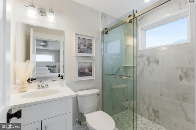 bathroom with toilet, an enclosed shower, ceiling fan, and a healthy amount of sunlight