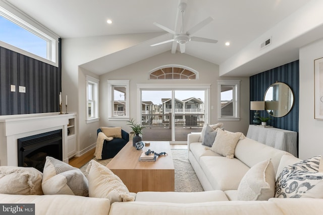 living room featuring lofted ceiling, light wood-type flooring, and ceiling fan