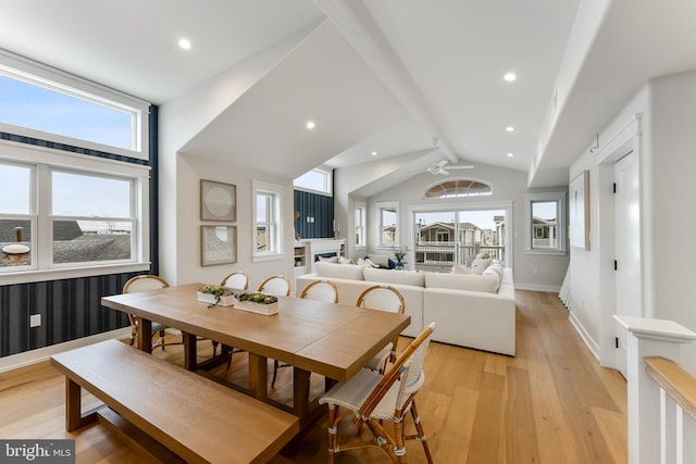 dining area with ceiling fan, vaulted ceiling with beams, and light wood-type flooring