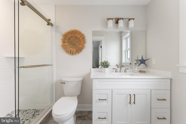 bathroom with vanity, a shower with shower door, and toilet