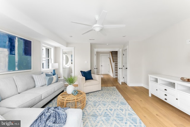 living room featuring ceiling fan and light hardwood / wood-style floors