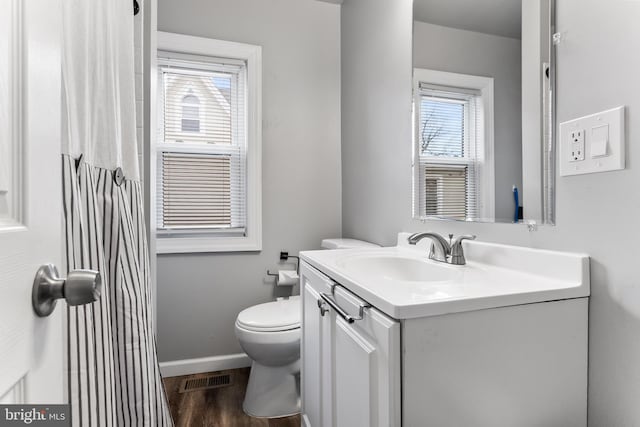 bathroom with toilet, vanity, and hardwood / wood-style flooring