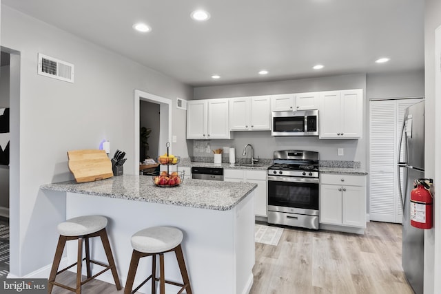 kitchen with appliances with stainless steel finishes, white cabinetry, and sink