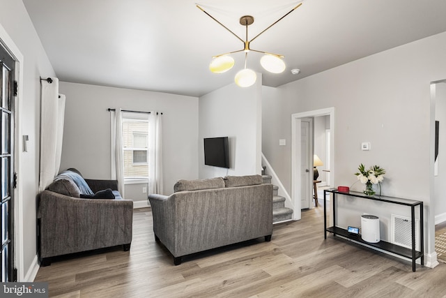 living room with an inviting chandelier and light hardwood / wood-style floors