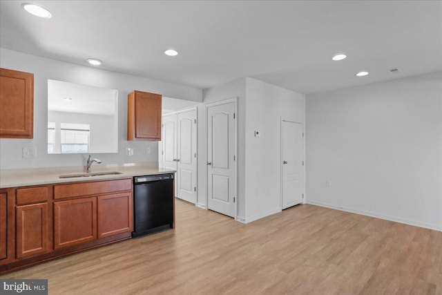 kitchen featuring black dishwasher, light hardwood / wood-style flooring, and sink