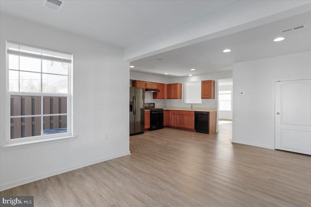 kitchen with sink, light hardwood / wood-style floors, and black appliances