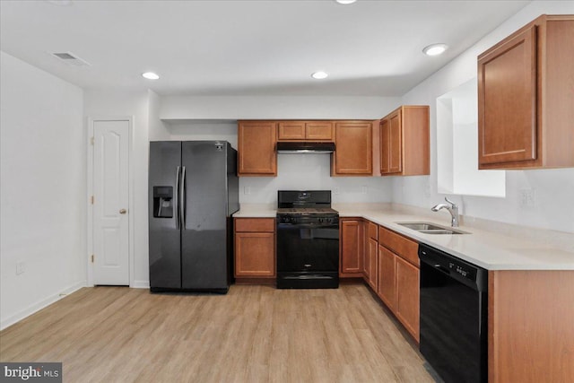 kitchen featuring light wood-type flooring, sink, and black appliances