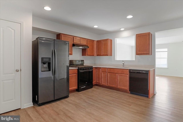 kitchen with light hardwood / wood-style floors, sink, and black appliances