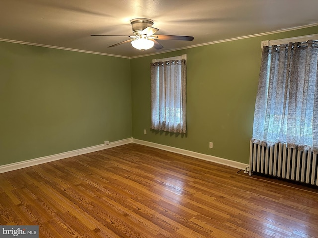 unfurnished room with radiator heating unit, hardwood / wood-style flooring, ceiling fan, and crown molding