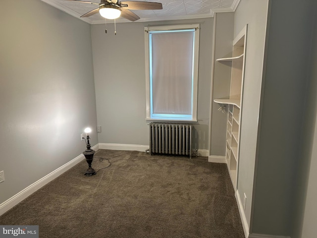 carpeted spare room featuring ceiling fan, radiator heating unit, and crown molding