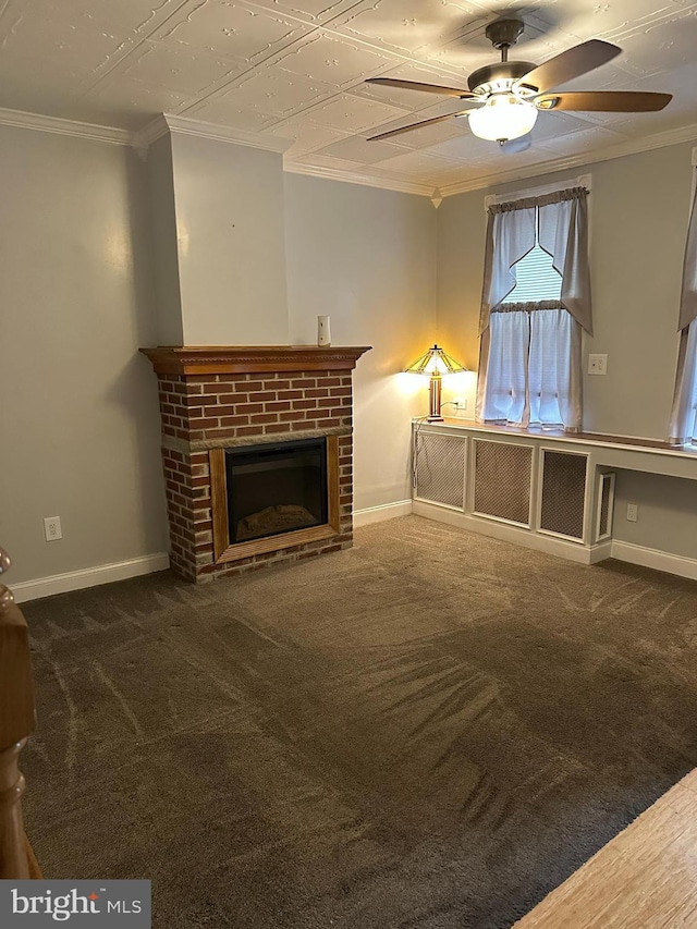 unfurnished living room featuring ceiling fan, dark carpet, crown molding, and a brick fireplace