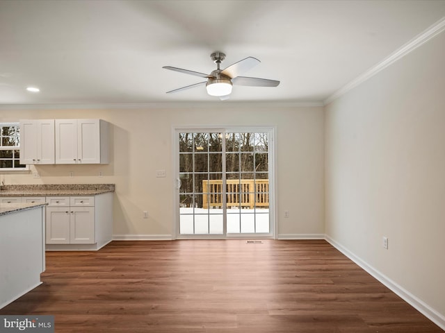 interior space featuring white cabinetry, ceiling fan, ornamental molding, and dark hardwood / wood-style floors