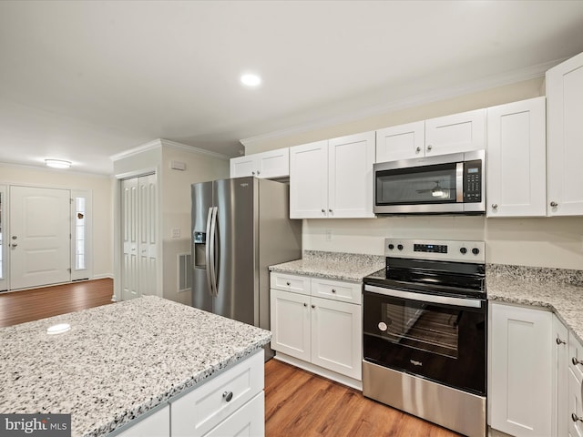 kitchen featuring appliances with stainless steel finishes, white cabinets, and light wood-type flooring