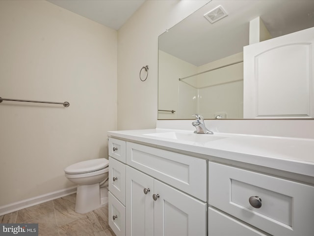 bathroom featuring vanity, toilet, and a shower