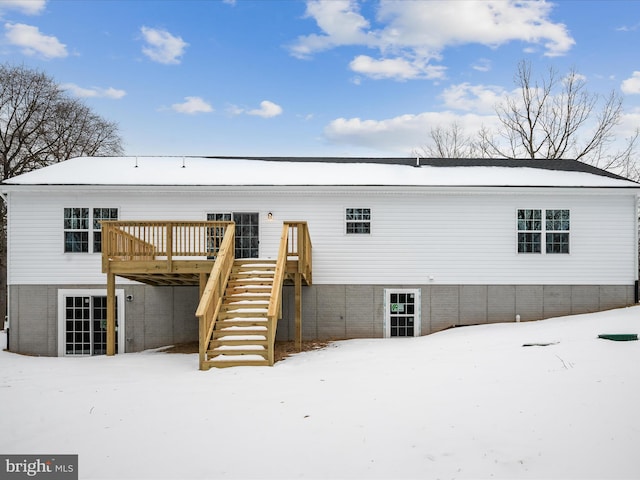 snow covered rear of property featuring a wooden deck