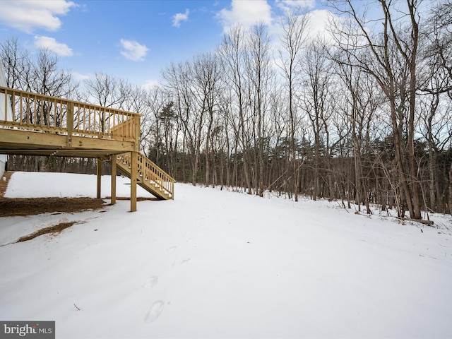 snowy yard featuring a wooden deck