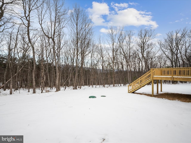 yard layered in snow with a wooden deck