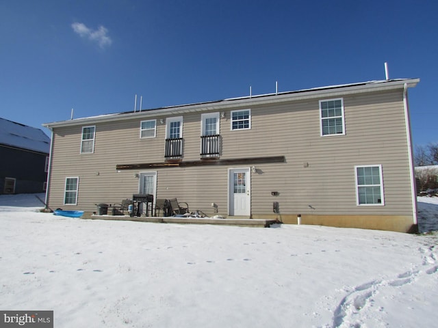 view of snow covered rear of property