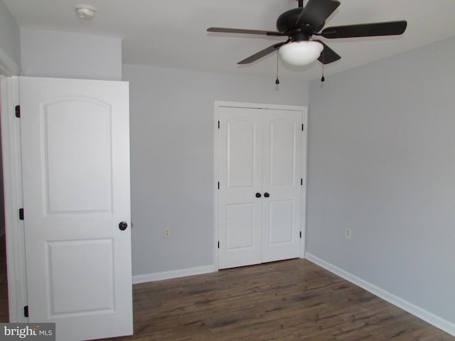 unfurnished bedroom featuring a closet, ceiling fan, and dark hardwood / wood-style floors