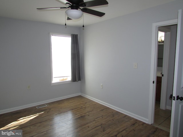 empty room featuring dark hardwood / wood-style flooring and ceiling fan