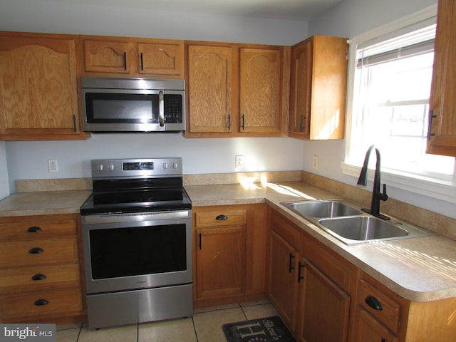 kitchen with sink, stainless steel appliances, and light tile patterned flooring