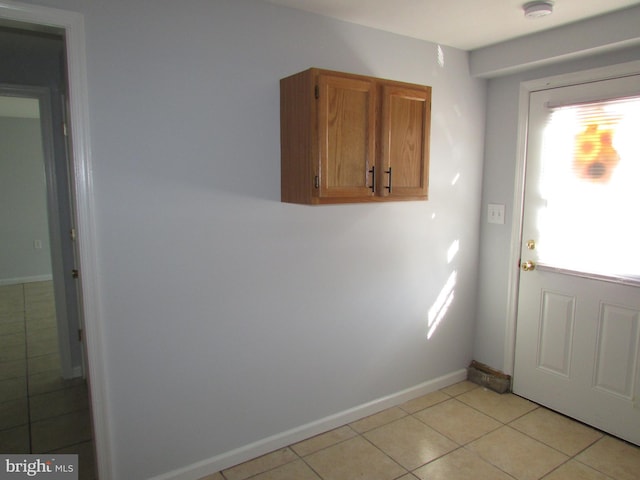 laundry area with light tile patterned floors